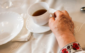 kobieca ręka trzymajaca białą filiżankę z herbatą