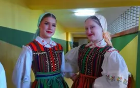 Dwie dziewczyny stojące w kolorowych strojach ludowych