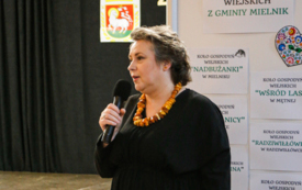 Kobeita w czarnej sukience trzymajaca mikrofon w ręku