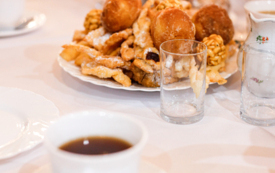 talerz pączk&oacute;w, fawork&oacute;w, szklanka i filiżanka z herbatą