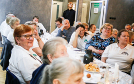publiczność z uśmiechami na twarzy siedząca na krzesłach