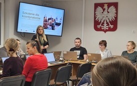 Na zdjęciu uczestnicy szkolenia. Przed każdym laptop. Na ścianie, na ekranie wyświetlana prezentacja.