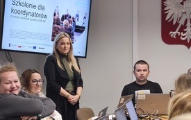 Na zdjęciu uczestnicy szkolenia. Przed każdym laptop. Na ścianie, na ekranach wyświetlana prezentacja.