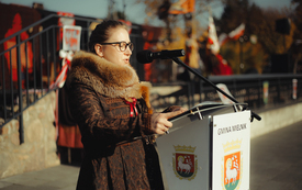 Zdjęcie przedstawia przemawiającą kobietę w przebraniu.