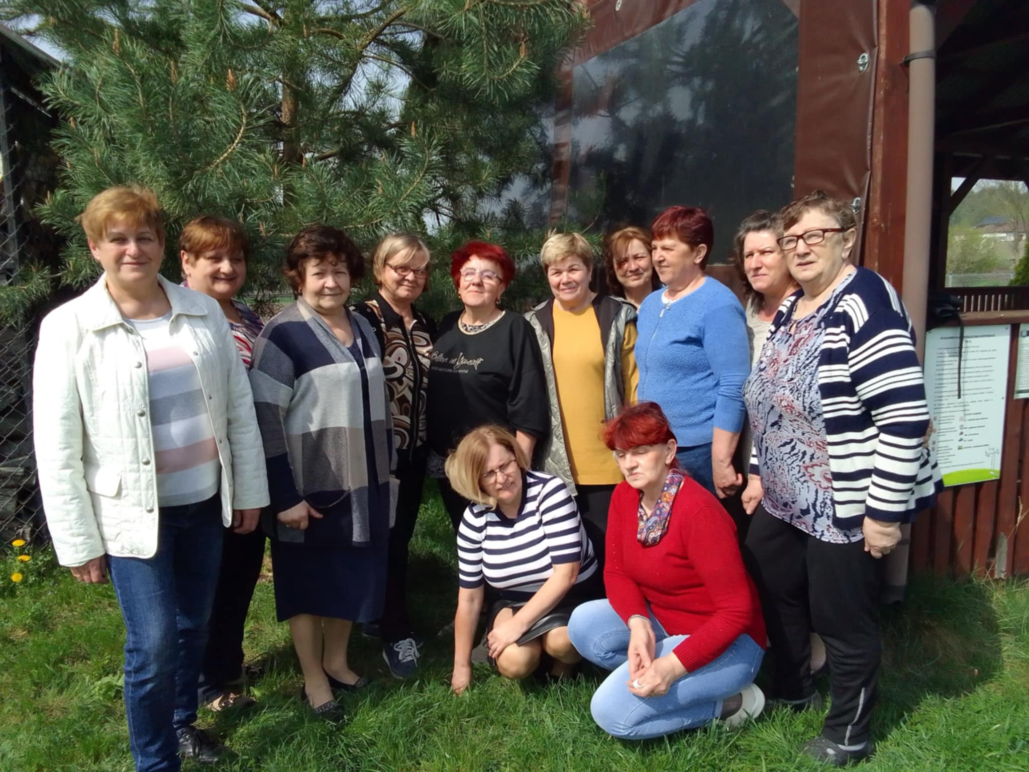Kobiety stojące przy drewnianym budynku.